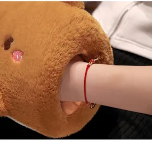 Close-up of a soft brown plush hand warmer pillow showing use with a hand inserted.