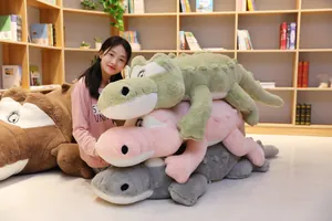 Grands oreillers en peluche crocodile de différentes couleurs avec mannequin asiatique