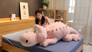 Scène de chambre avec un grand oreiller long en peluche crocodile rose pour dormir