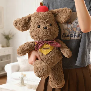 Adorable brown curly plush puppy toy wearing a red apple hat and a yellow scarf