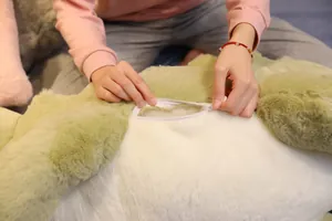 Gros plan de la fermeture éclair d'un grand oreiller en peluche crocodile vert