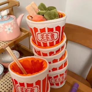 Détail montrant un ensemble créatif de peluches oden avec des bols rouges empilés et des aliments