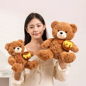 Süßer brauner Teddybär aus Plüsch mit Honigtopf, präsentiert von einem lächelnden Model
