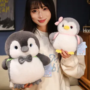 Chubby penguin plush toy backpack held by a model in a cozy indoor setting