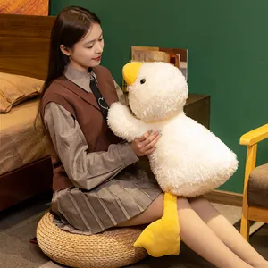 Adorable soft white plush duck toy pillow being held by a girl in a cozy bedroom setting