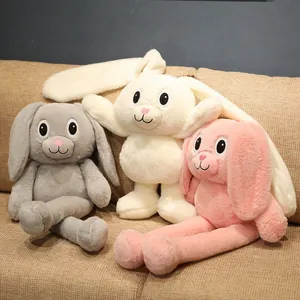 Three cute plush bunnies with stretchable ears and long legs displayed on a cozy sofa