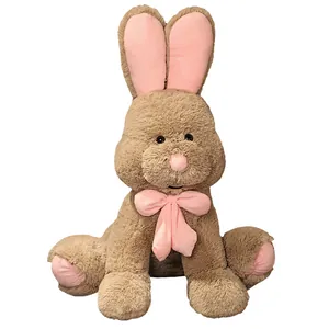 Large brown plush bunny toy with soft pink ears and a cute bow tie on white background.