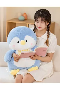 Soft blue plush penguin toy held by a young woman sitting comfortably on a sofa