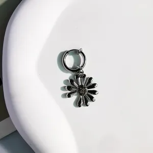 Dettaglio di ciondolo a margherita vintage su orecchino a cerchio in argento
