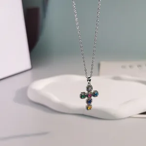Close-up of cross pendant featuring vibrant colorful cubic zirconia on a silver chain