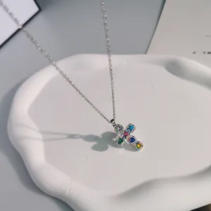 Close-up of a vibrant cross pendant necklace with colorful cubic zirconia stones.