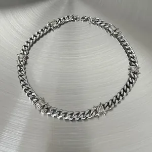 Detailed view of silver Cuban link necklace featuring industrial barbed wire thorn design