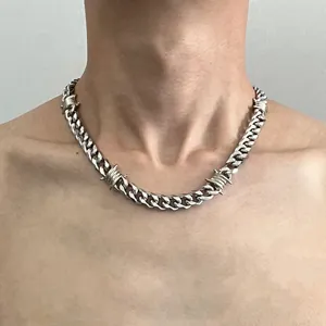Close-up detail of a silver thorn Cuban link chain necklace worn on a male model neck