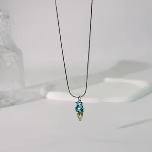 Nahaufnahme einer Titanstahlkette mit drei vertikalen blauen und gelben Steinen.