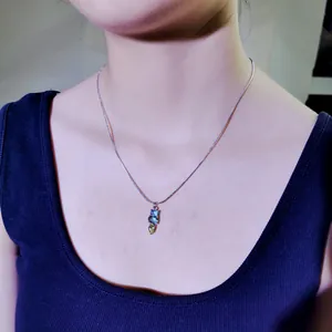 Detailansicht einer minimalistischen Titanstahl-Halskette mit bunten Edelsteinanhängern.