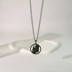 Vista detallada de un collar con colgante de gato negro minimalista en cadena de plata elegante
