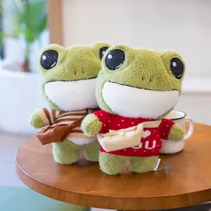 Two cute green frog plush toys with big eyes wearing stylish sweaters and bags on table