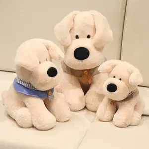 Cute Labrador plush dog toys in three sizes with decorative scarves on a soft sofa.