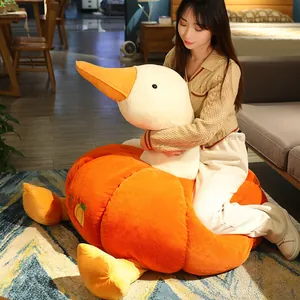 Creative large pumpkin goose plush toy being hugged by a person in a cozy home setting
