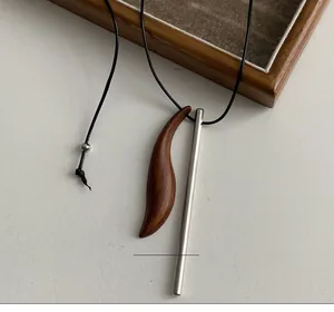 Dettaglio di pendenti in legno di sandalo e acciaio su una collana lunga vintage