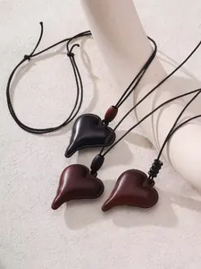 Vue détaillée de colliers pendentifs en forme de cœur vintage avec cordons en cuir lisse.