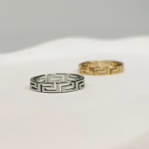 Dettaglio di anelli in acciaio inossidabile con motivo geometrico in oro e argento.
