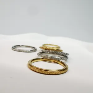 Vista ravvicinata della trama satinata di eleganti anelli minimalisti in oro e argento