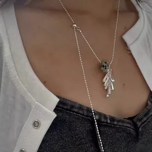 Detailaufnahme einer Silberhalskette mit einem Anhänger in Form einer Traubendolde.