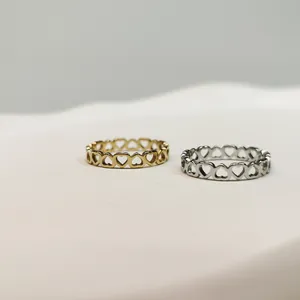 Primo piano di anelli in acciaio inossidabile oro e argento con design a cuore cavo