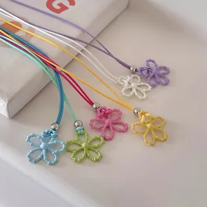 Ciondoli a forma di fiore traforati colorati su cordini vivaci in varie tonalità dopamine.