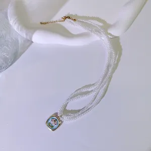 Detail der französischen Vintage-Perlenkette mit dreilagigem Emaille-Blumenanhänger.