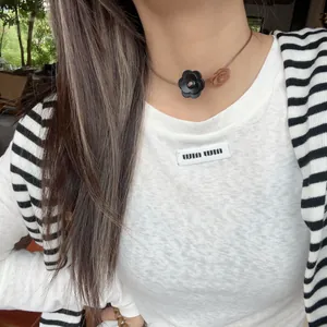 Detailed view of retro wooden flower choker with thin leather cord on model's neck