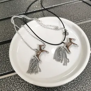 Detailansicht der Retro-Pferde-Quastenanhänger mit silberner Kette und Kristallen