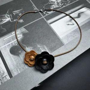 Detail of retro wooden flower choker with brown leather cord and adjustable chain