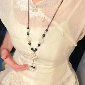Nahaufnahme einer Vintage-Halskette mit Keramikblume im ethnischen Stil am Modell