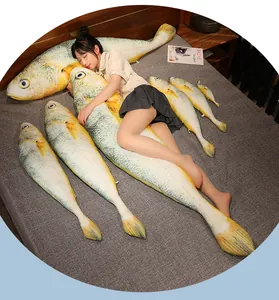 Large realistic yellow croaker fish plush pillow series in various sizes on a bed.