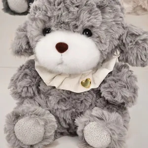 Adorable fluffy gray poodle plush toy wearing a white ruffled collar with a golden heart