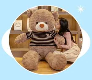 Detailed view of a giant brown teddy bear plush toy wearing a striped knitted sweater
