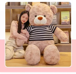 Detail of a large soft teddy bear plush toy wearing a striped sweater in a library
