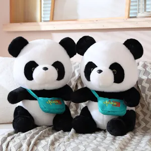 Two adorable giant panda plush toys with teal 'China' bags sitting on a cozy sofa.