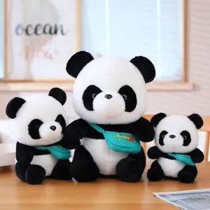 Set of three cute panda plush toys with teal crossbody bags displayed on a wooden table