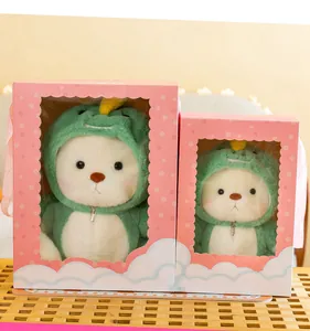 Detailansicht zweier Gelenk-Teddybären in Dinosaurier-Kostümen in rosa Geschenkboxen mit Fenster
