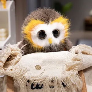Lifelike owl plush toy with big eyes sitting in a fringed canvas bag for birthday gift