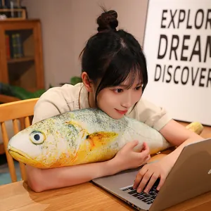 Funny and creative realistic yellow croaker plush pillow held by a girl at a laptop desk