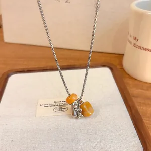 Close-up detail of a minimalist natural stone grape cluster pendant necklace on a tray