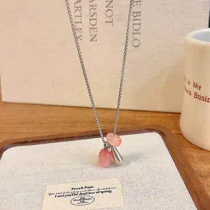 Close-up of pink natural stone and silver drop pendants on a delicate adjustable necklace