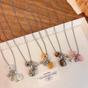 Assorted natural stone cluster pendant necklaces in five colors on a display tray