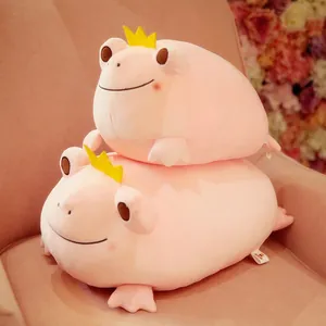 Detailed view of two stacked cute pink crown frog plush toys on a soft pink armchair