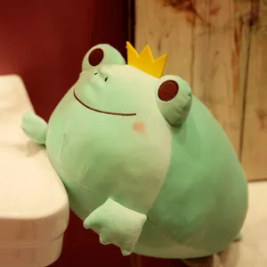 Macro view showing the soft texture of a mint green frog plush toy with a yellow crown
