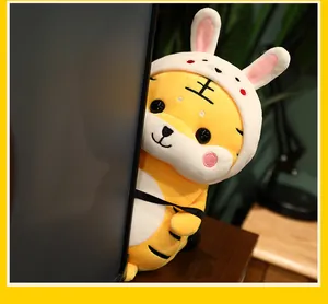 Nahaufnahme eines Plüschtigers mit Hasenohren-Hut, der hinter dem Schirm hervorschaut.